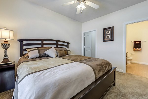 Cozy bedroom with modern decor at Copper Chase at Stones Crossing Apartments, offering luxurious living by Greystar
