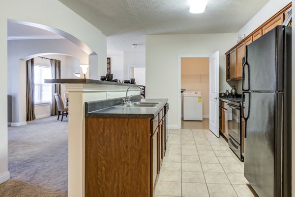 Modern kitchen with stainless steel appliances and granite countertops at Copper Chase at Stones Crossing Apartments