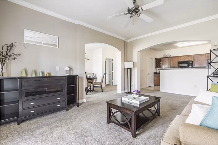 Living room with cozy modern decor and large windows at Copper Chase at Stones Crossing Apartments