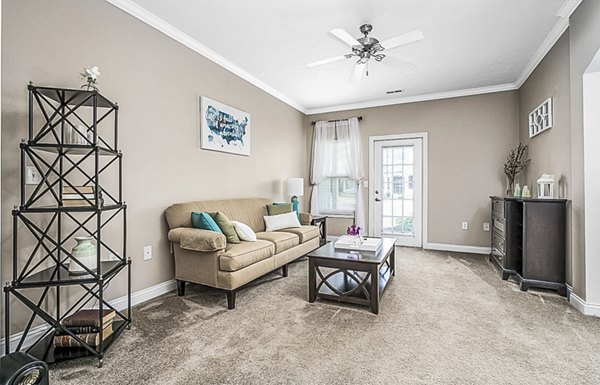 Living room with cozy modern decor and large windows at Copper Chase at Stones Crossing Apartments
