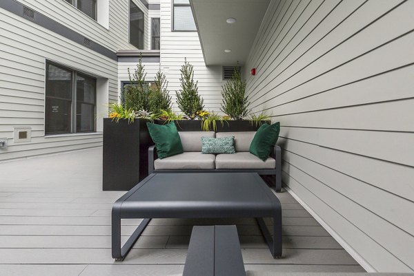 Cozy outdoor patio with comfortable seating at Wheelhouse Apartments, ideal for relaxation and alfresco dining