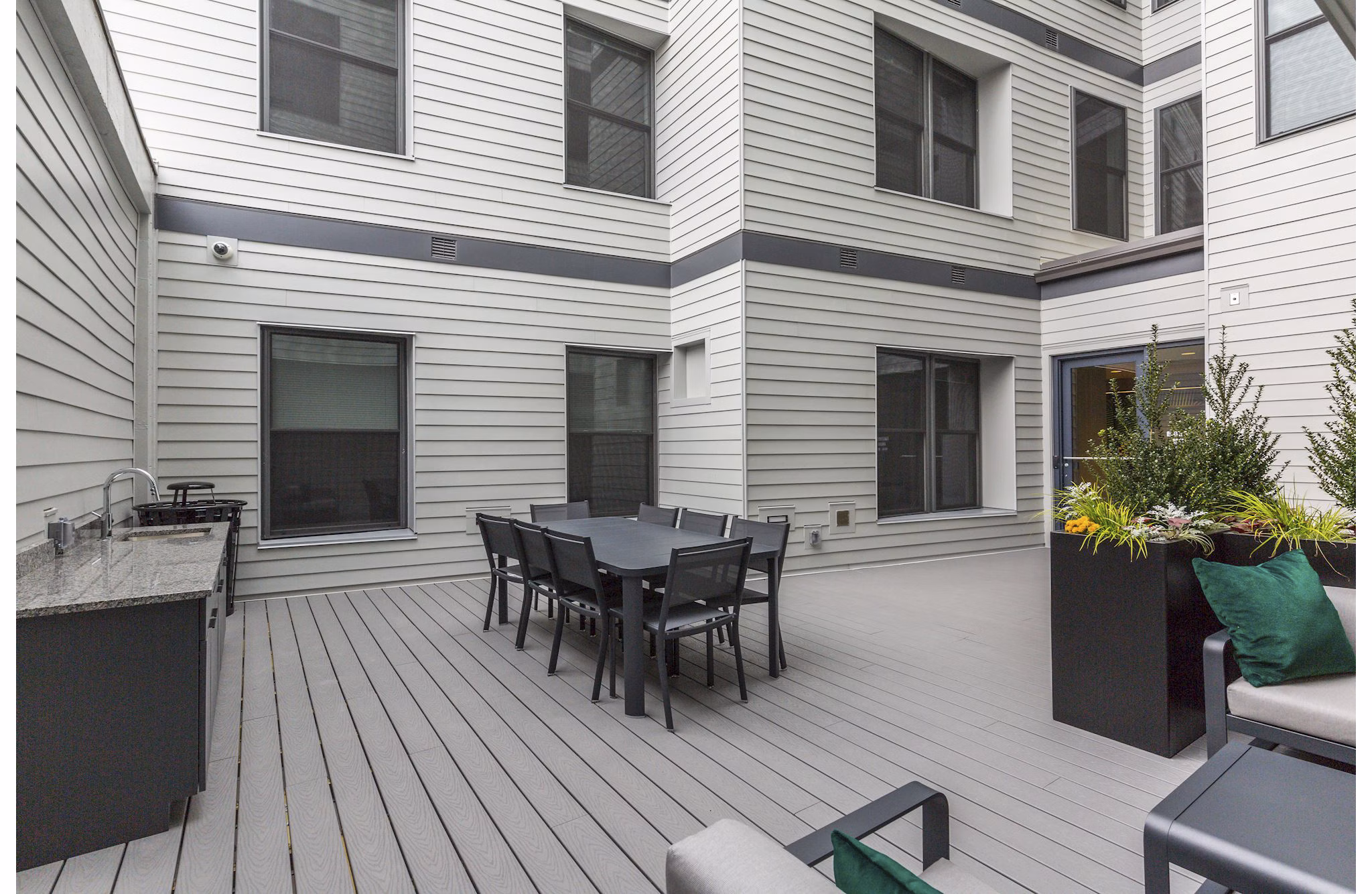 Courtyard with lush greenery and seating areas at Wheelhouse Apartments, ideal for relaxation and outdoor gatherings