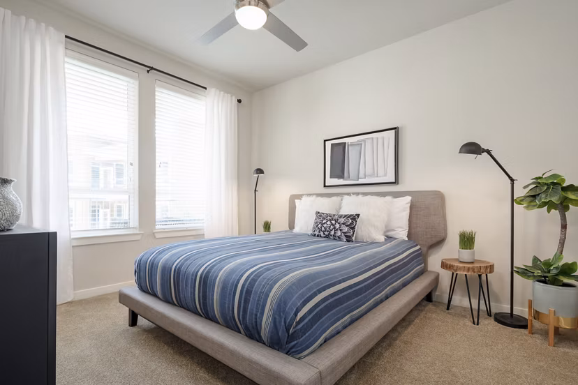 Bedroom with elegant furnishings and neutral tones at The Upton at Longhorn Quarry Apartments
