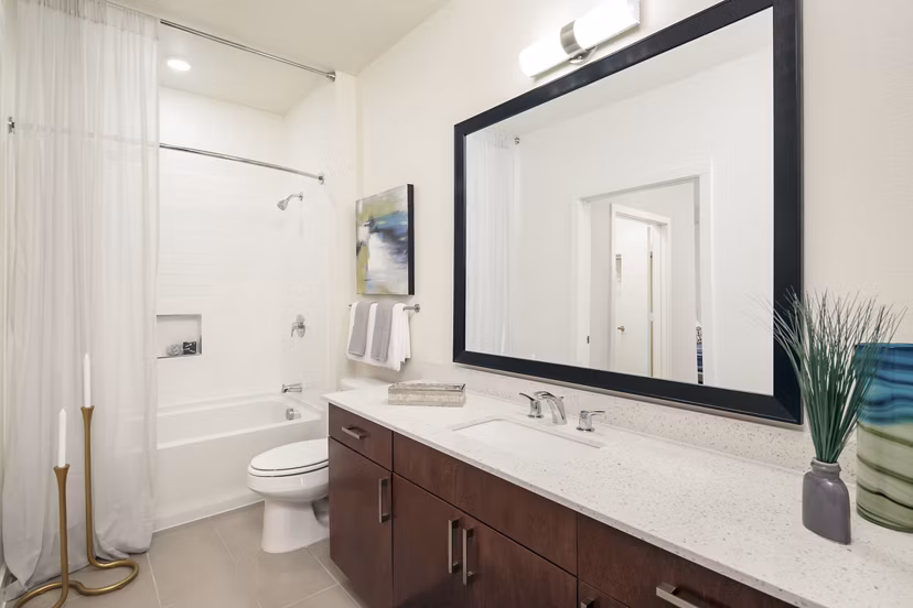 Modern bathroom with marble countertops and dual sinks at The Upton at Longhorn Quarry Apartments