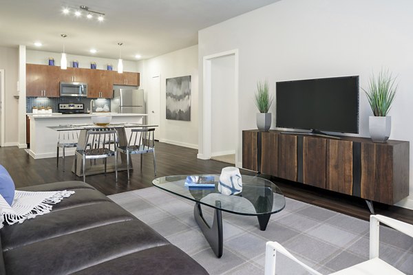 Living room with modern furniture and natural light at The Upton at Longhorn Quarry Apartments