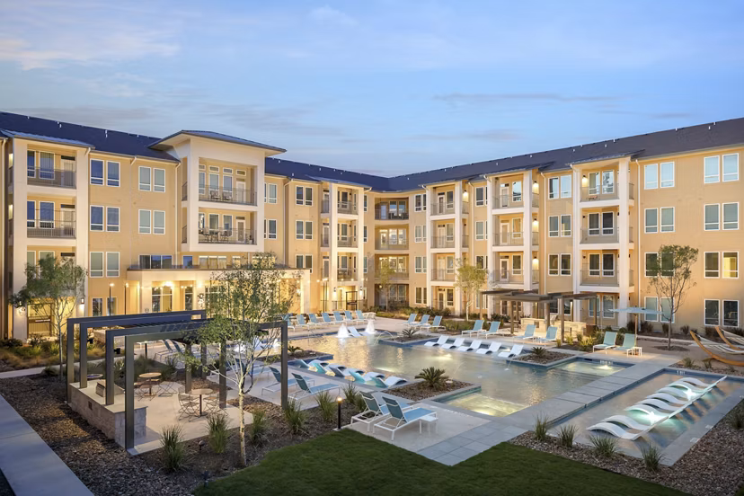 Outdoor pool with modern lounge chairs at The Upton at Longhorn Quarry Apartments