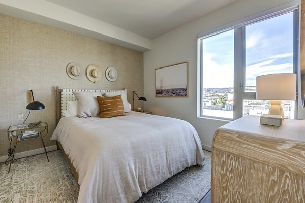 Modern bedroom featuring plush bedding and large windows at Linea Apartments for luxury living