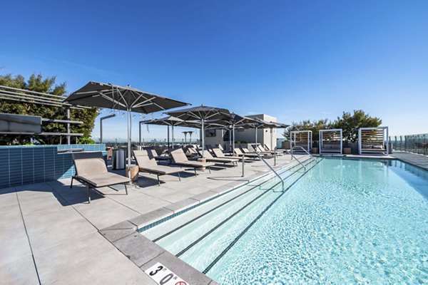 Outdoor pool with lounge chairs at Linea Apartments, a luxury property by Greystar