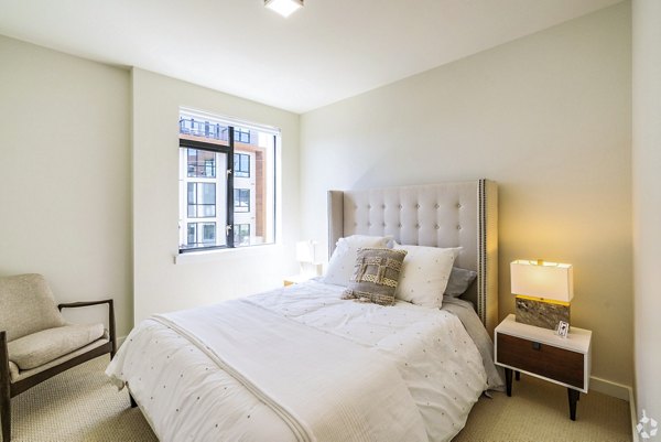 Cozy bedroom with plush decor and large windows at 777 Tenn Apartments, a luxury Greystar property in vibrant downtown Nashville