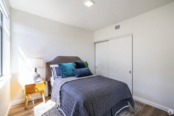 Bedroom featuring modern decor and large windows at 777 Tenn Apartments, a luxury residence by Greystar