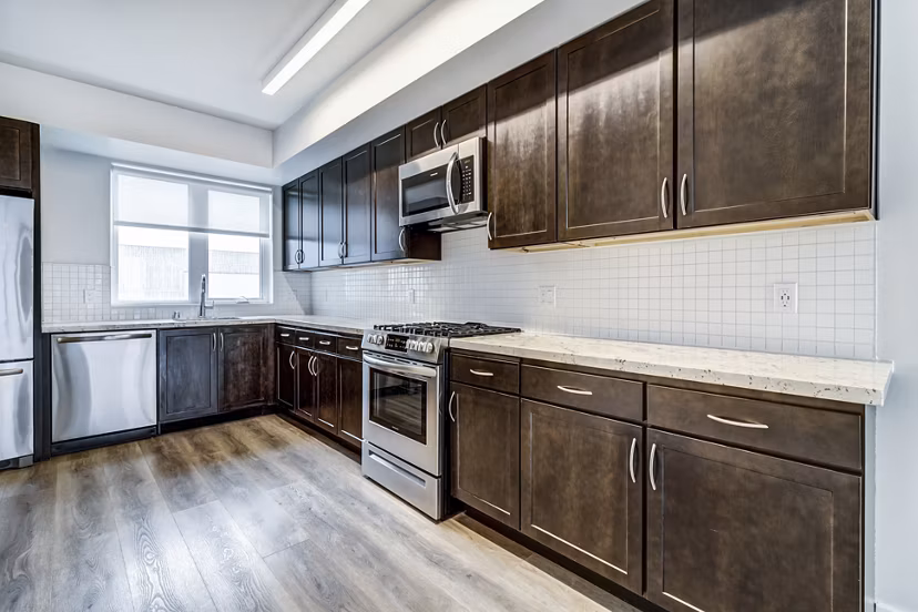 Modern kitchen with stainless steel appliances and granite countertops at 777 Tenn Apartments in Nashville