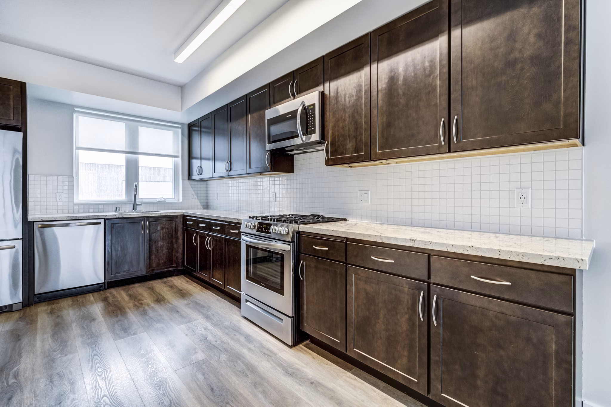 Modern kitchen with stainless steel appliances and granite countertops at 777 Tenn Apartments in Nashville