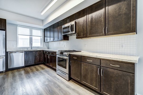 Modern kitchen with stainless steel appliances and granite countertops at 777 Tenn Apartments in Nashville