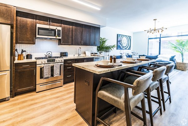 Modern kitchen with stainless steel appliances and granite countertops at 777 Tenn Apartments
