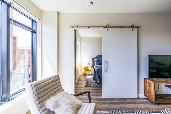 Spacious living room with modern decor and large windows at 777 Tenn Apartments, offering luxury living in Nashville