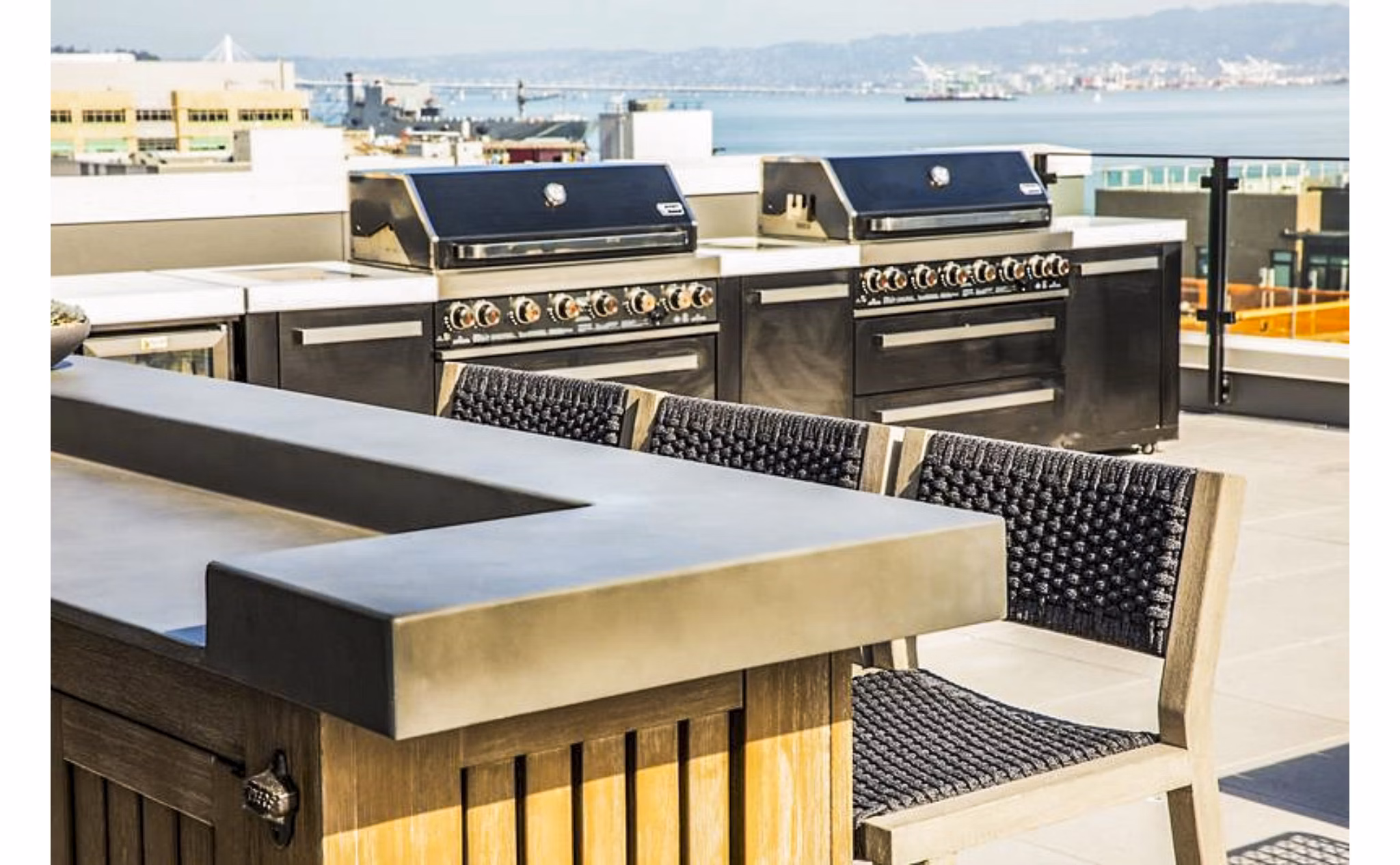 Outdoor grill area and patio at 777 Tenn Apartments featuring modern furniture and greenery, perfect for social gatherings and relaxation