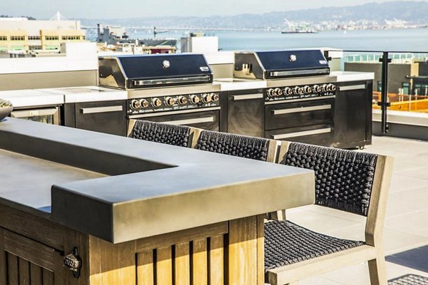 Outdoor grill area and patio at 777 Tenn Apartments featuring modern furniture and greenery, perfect for social gatherings and relaxation