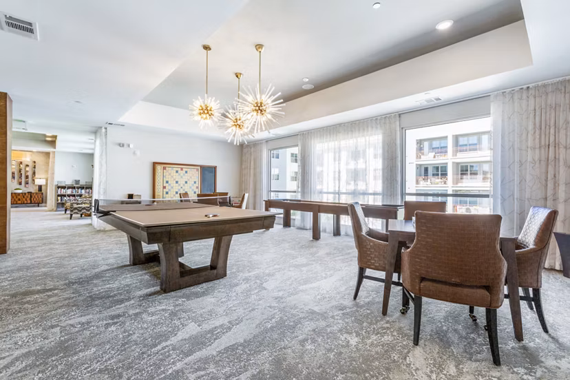 Game room with pool table and arcade games at Overture Albuquerque Apartments, ideal for leisure and entertainment