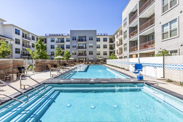 Outdoor pool with sun loungers at Overture Albuquerque Apartments