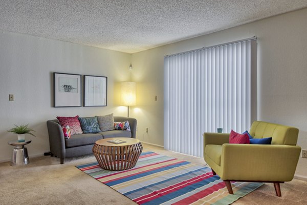 Stylish living room with modern decor and large windows in Pinehurst Apartments