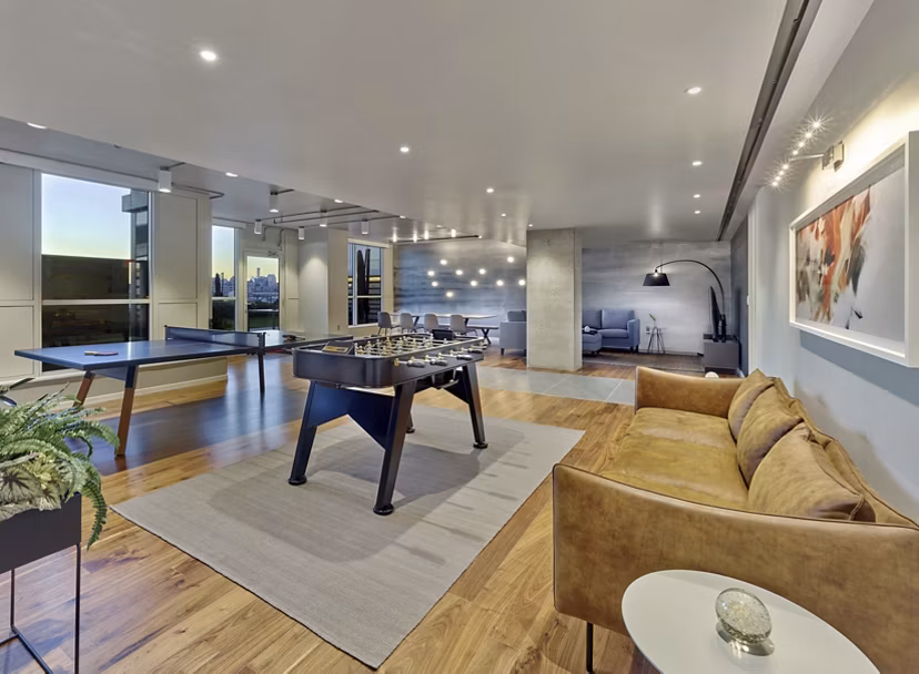 Modern game room featuring billiards and lounge seating in 7 Seventy House Apartments, ideal for entertainment and relaxation