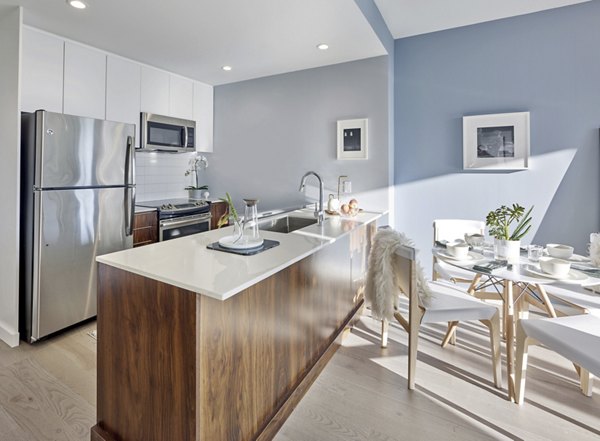 Modern kitchen featuring stainless steel appliances and sleek countertops at 7 Seventy House Apartments