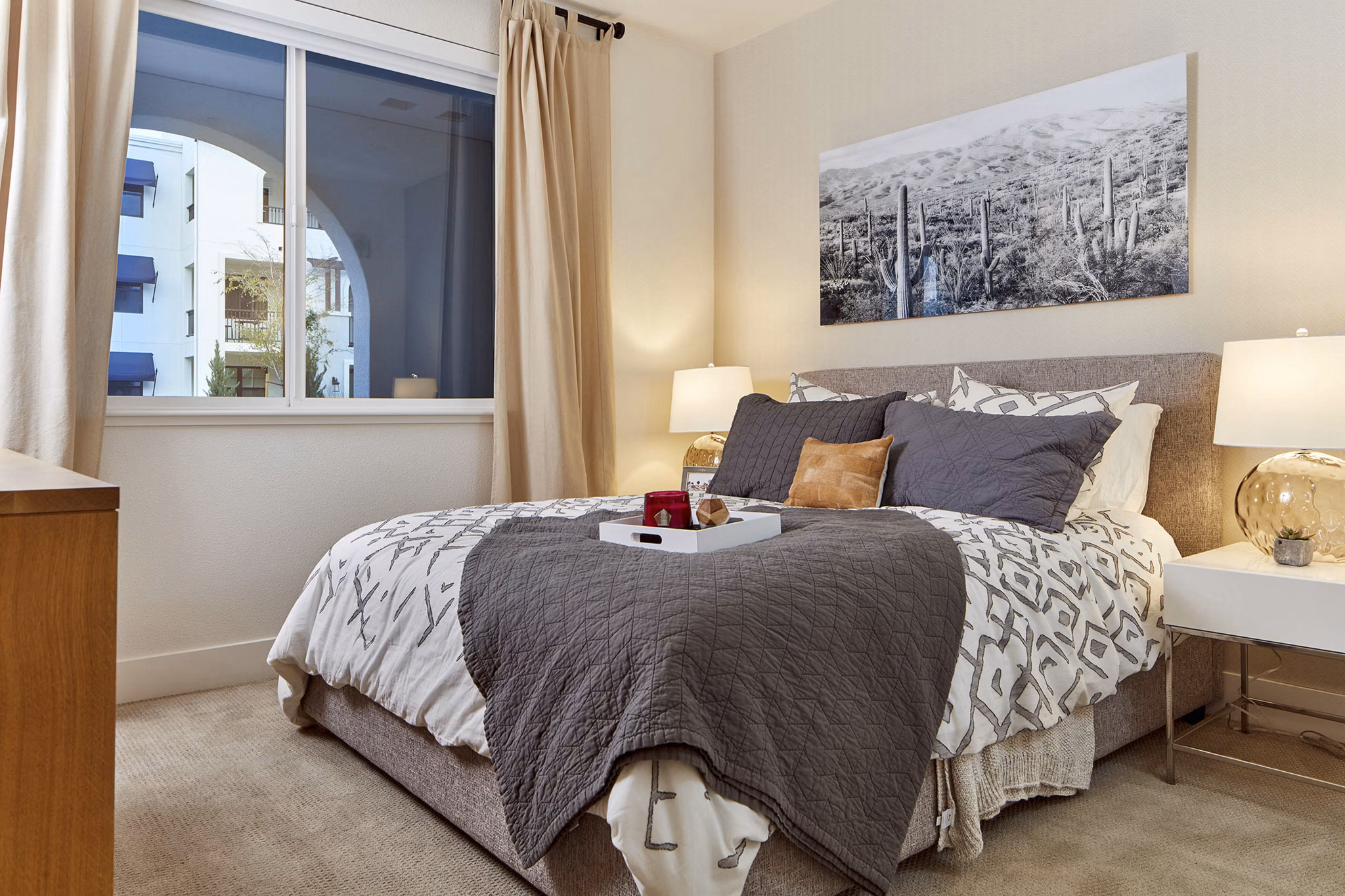 Cozy bedroom with elegant decor, plush bed, and natural light in luxury apartments