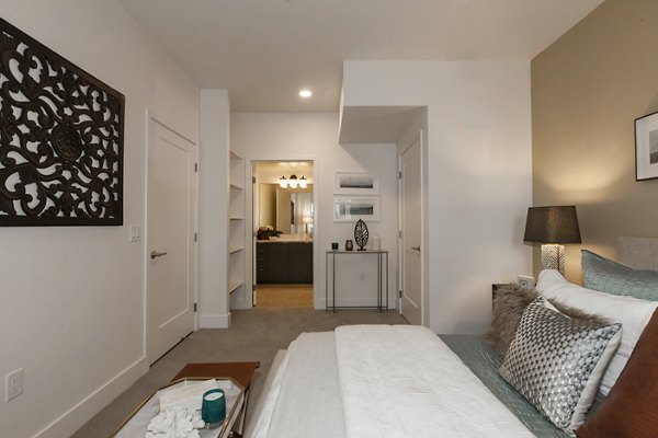 Bedroom featuring modern decor and plush bedding at Encasa Apartments