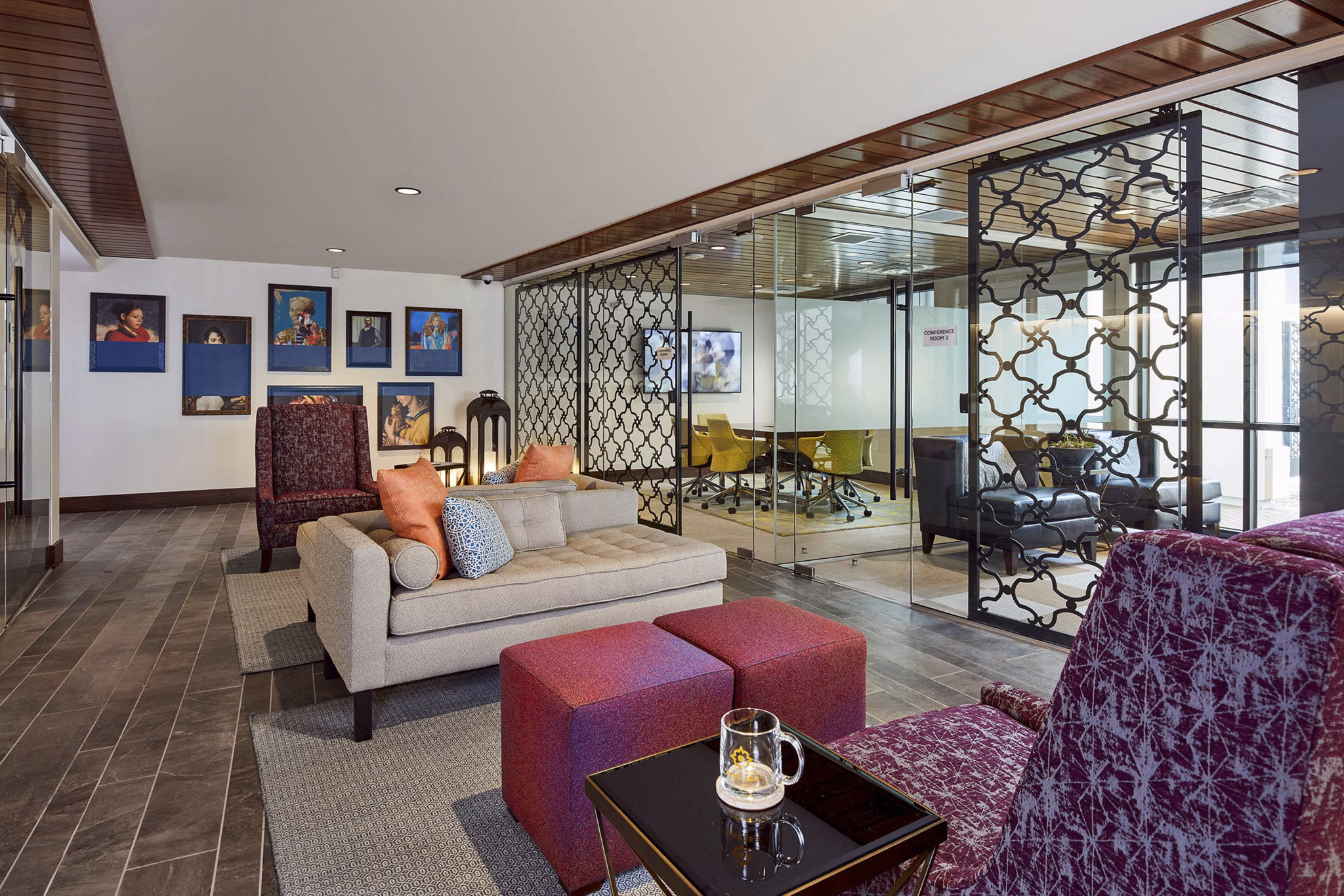 Modern office lounge area with comfortable seating and a glass-walled conference room