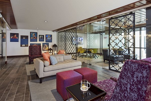 Modern office lounge area with comfortable seating and a glass-walled conference room