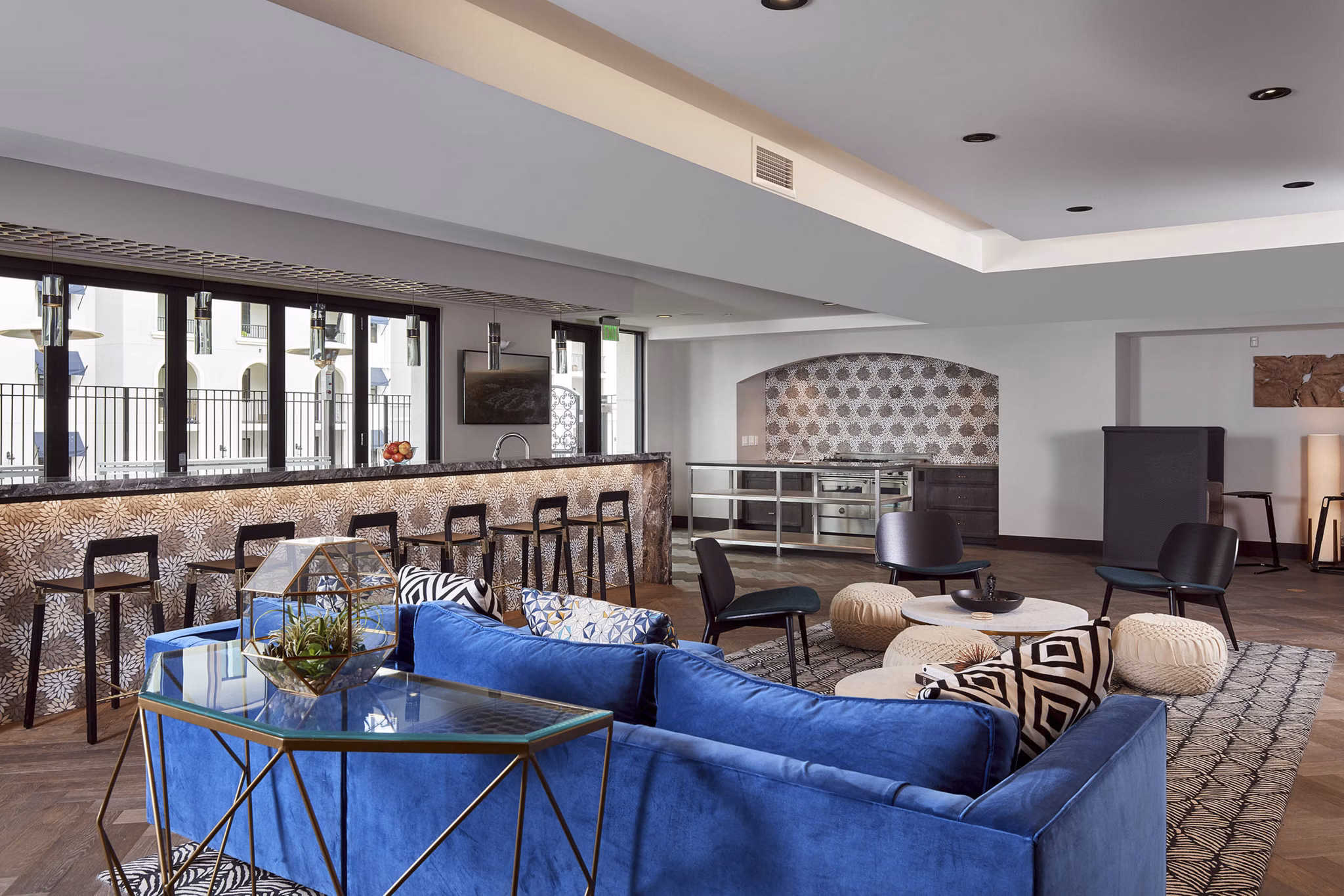 Modern living room with a blue sofa and bar counter in luxury apartments