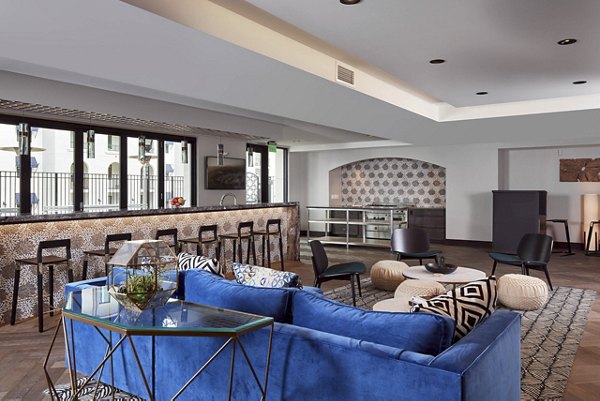 Modern living room with a blue sofa and bar counter in luxury apartments