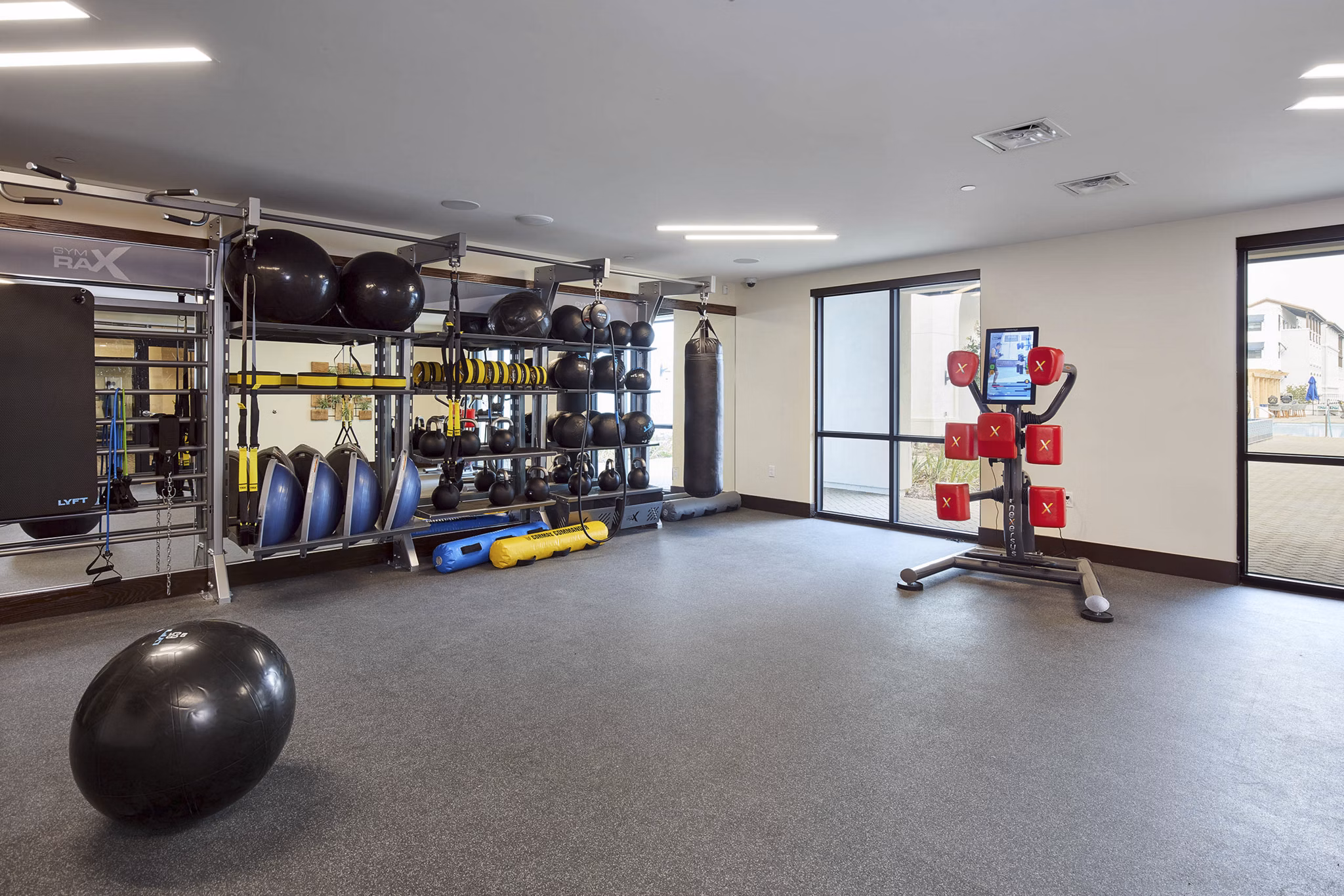 Fitness center with modern exercise equipment, including stability balls and a punching bag