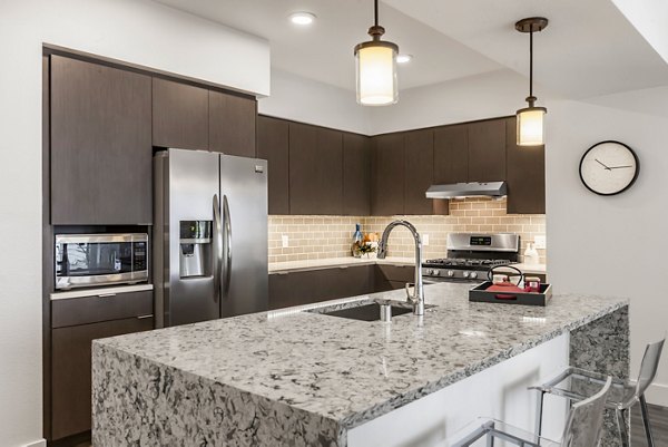 Spacious kitchen with modern appliances and granite countertops at Encasa Apartments