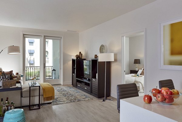 Modern living room and dining area with stylish furniture and a bowl of apples on the counter in luxury apartments
