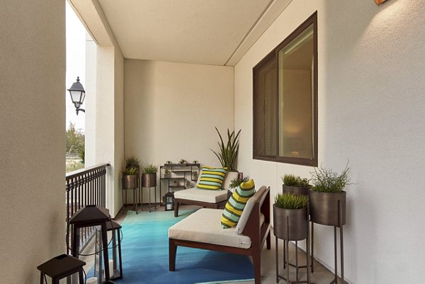 Balcony area with comfortable chairs, cushions, and potted plants for relaxation in luxury apartments