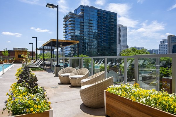 Resort-style pool at Piedmont House Apartments with lounge seating and lush landscaping