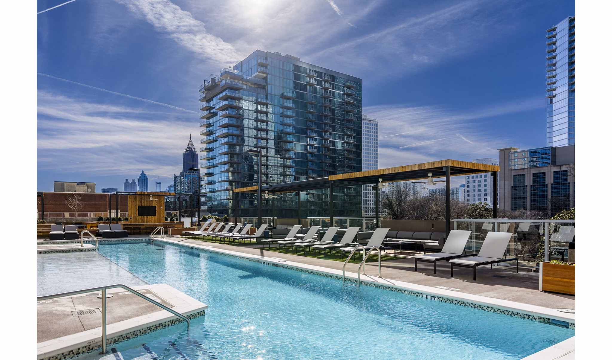 Poolside resort vibes at Piedmont House Apartments with sun loungers and city views
