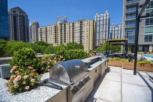 Grill area with modern seating at Piedmont House Apartments with cityscape view