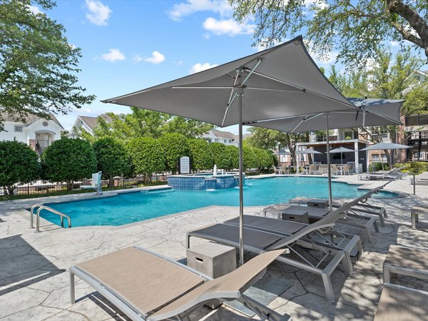 Relaxing pool area with sun loungers at Eleven11 Lexington at Flower Mound Apartments