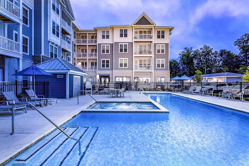Spacious rooftop pool with lounge chairs and city views at Everleigh Short Pump Apartments, a luxury Greystar community