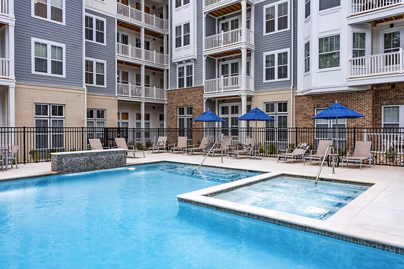 Outdoor pool with lounge chairs at Everleigh Short Pump Apartments, offering relaxation and leisure for residents