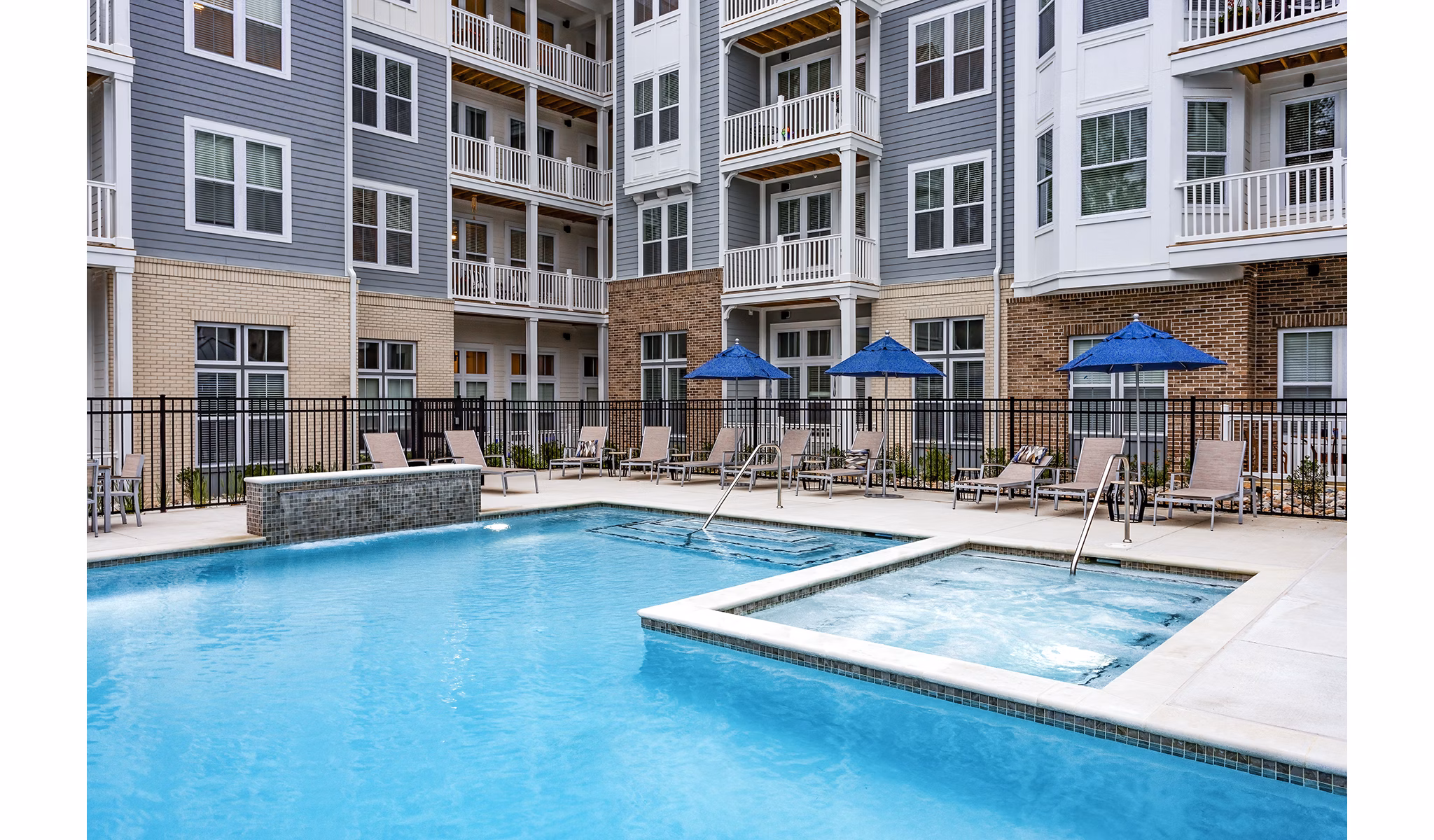 Outdoor pool with lounge chairs at Everleigh Short Pump Apartments, offering relaxation and leisure for residents