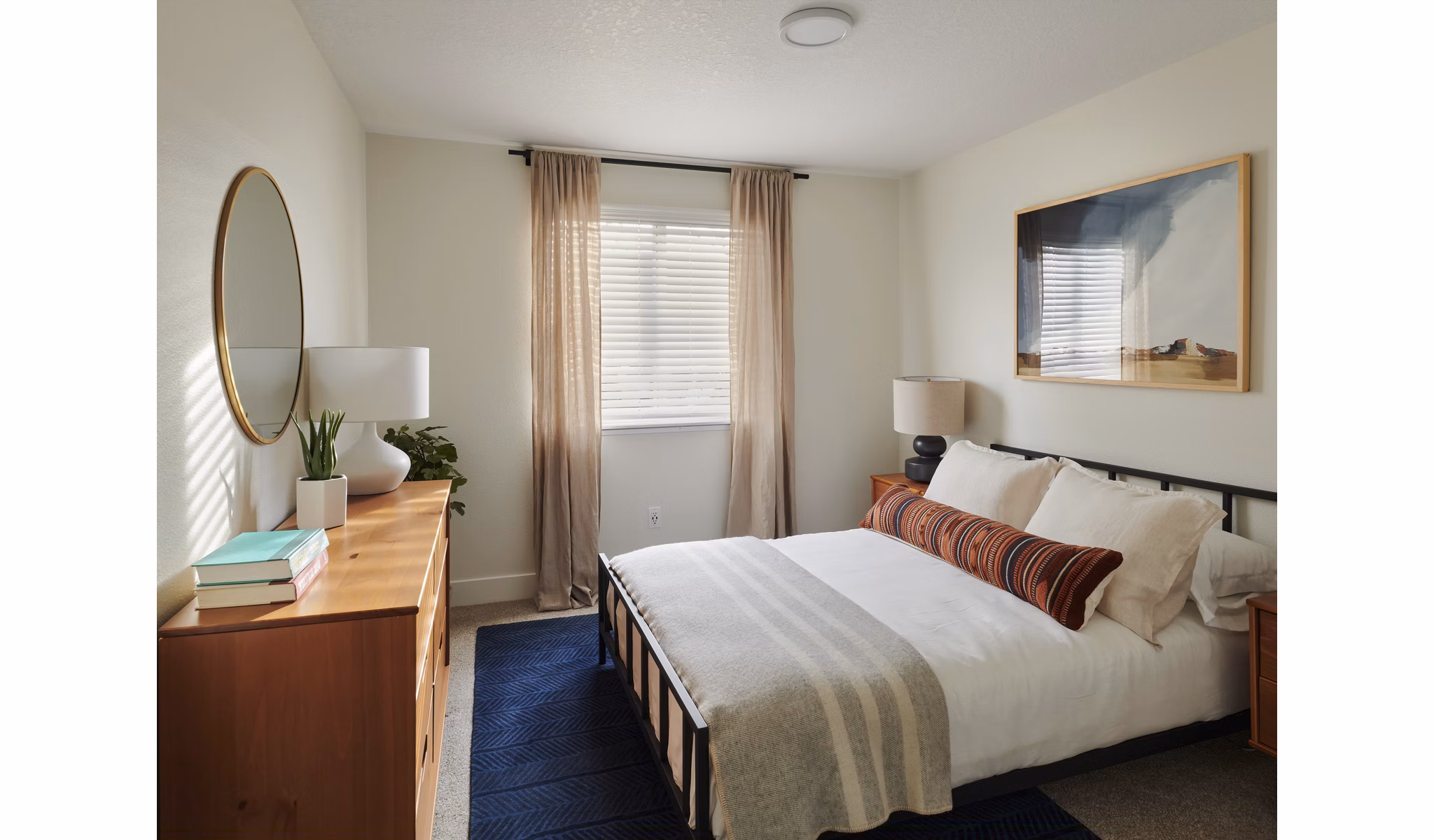 Bedroom featuring modern decor and large windows in Cedar House Apartments
