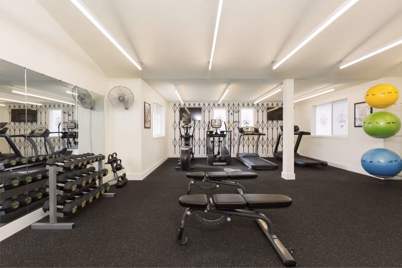 Modern fitness center with cardio machines at Cedar House Apartments