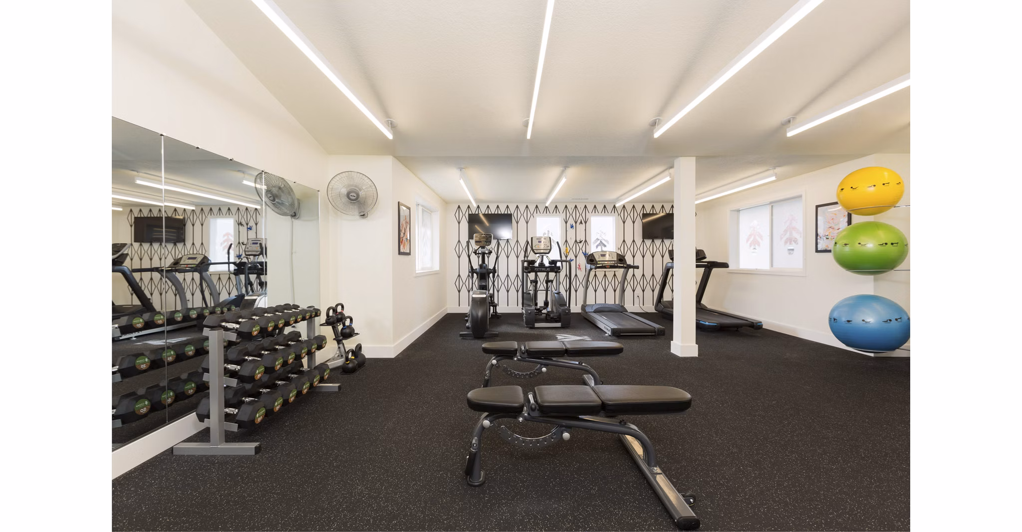 Modern fitness center with cardio machines at Cedar House Apartments