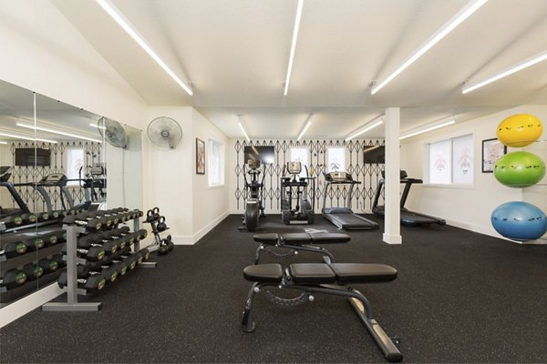 Modern fitness center with cardio machines at Cedar House Apartments