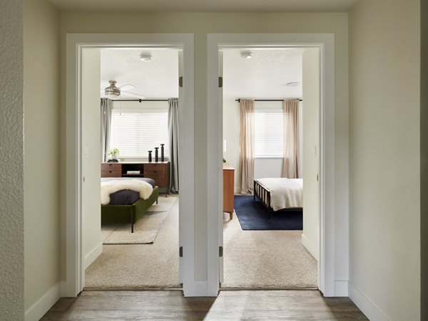 Hallway with modern lighting and hardwood floors at Cedar House Apartments, highlighting upscale design and comfort