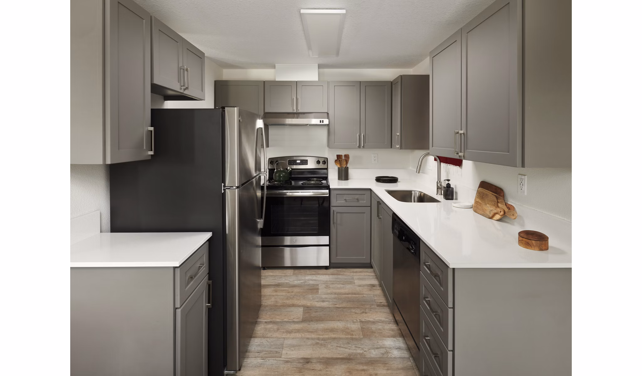 Modern kitchen featuring sleek countertops and stainless steel appliances in Cedar House Apartments