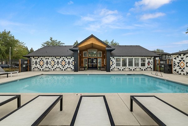Resort-style outdoor pool with sun loungers at Cedar House Apartments Perfect for relaxation and leisure